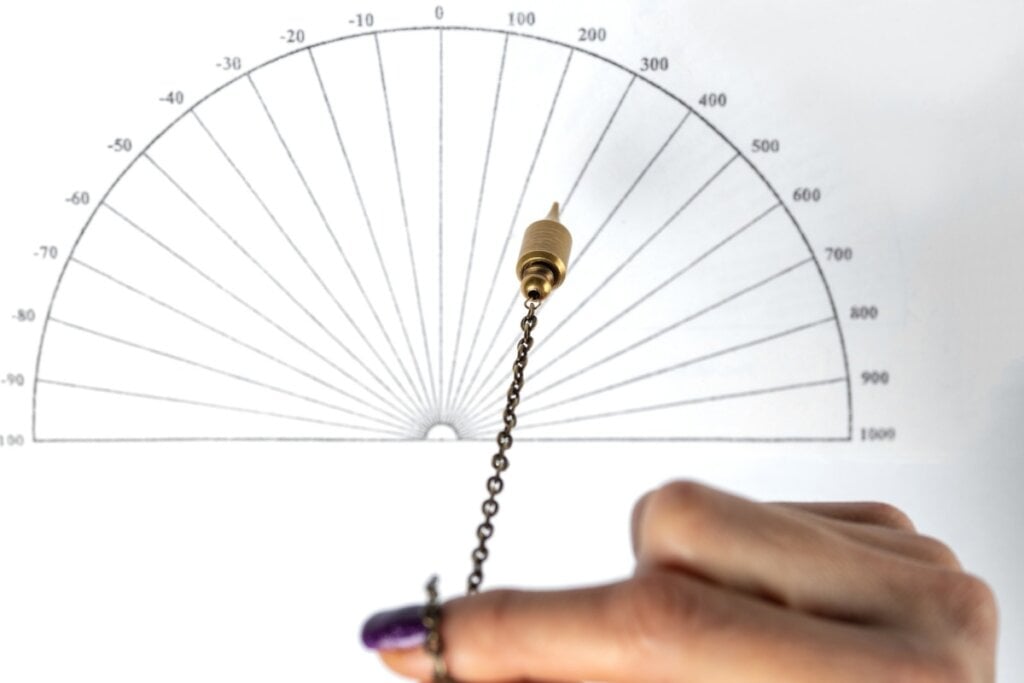 Pessoa com pêndulo em cima de um gráfico radiônico