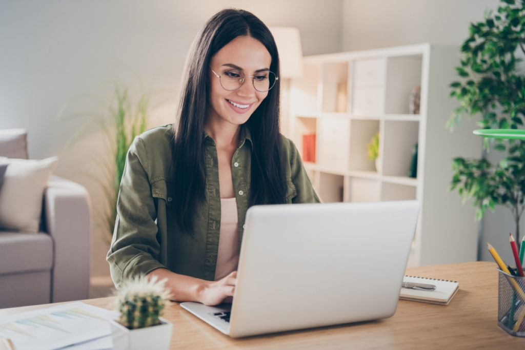 mulher sorrindo usando notebook em escritório