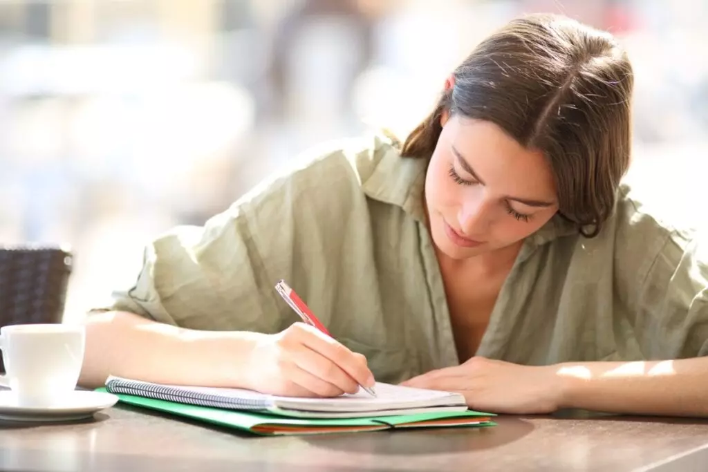 Jovem estudando e escrevendo concentrada