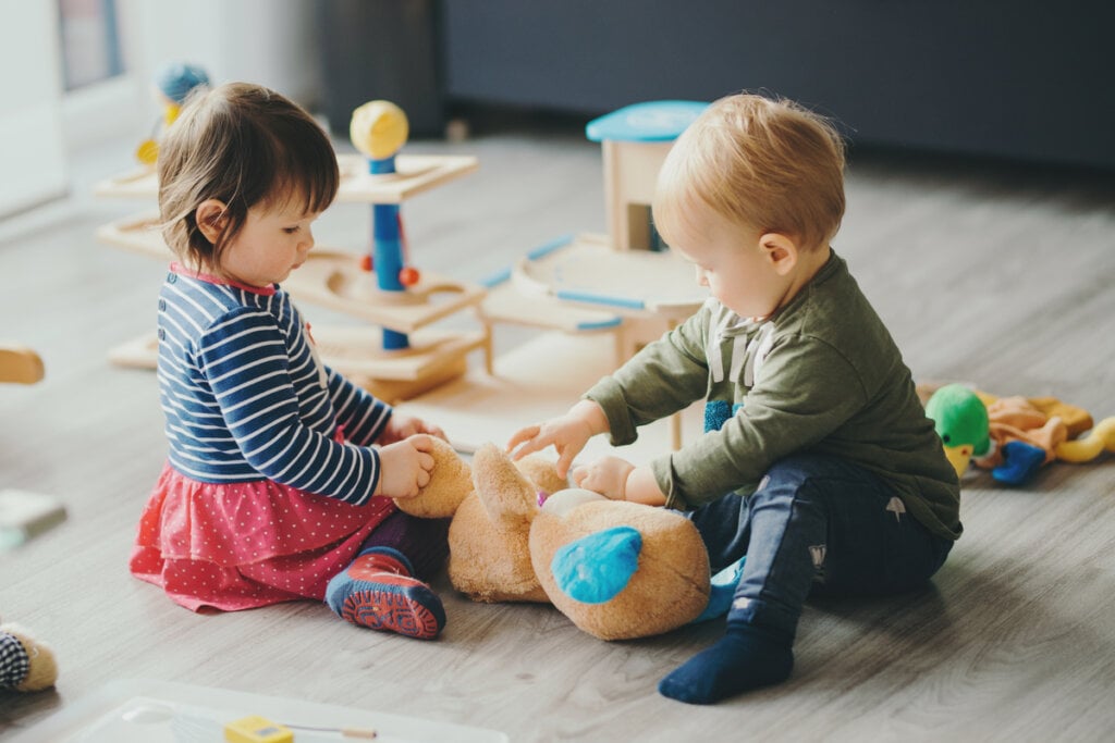 Menina e menino brincando em uma sala de estar