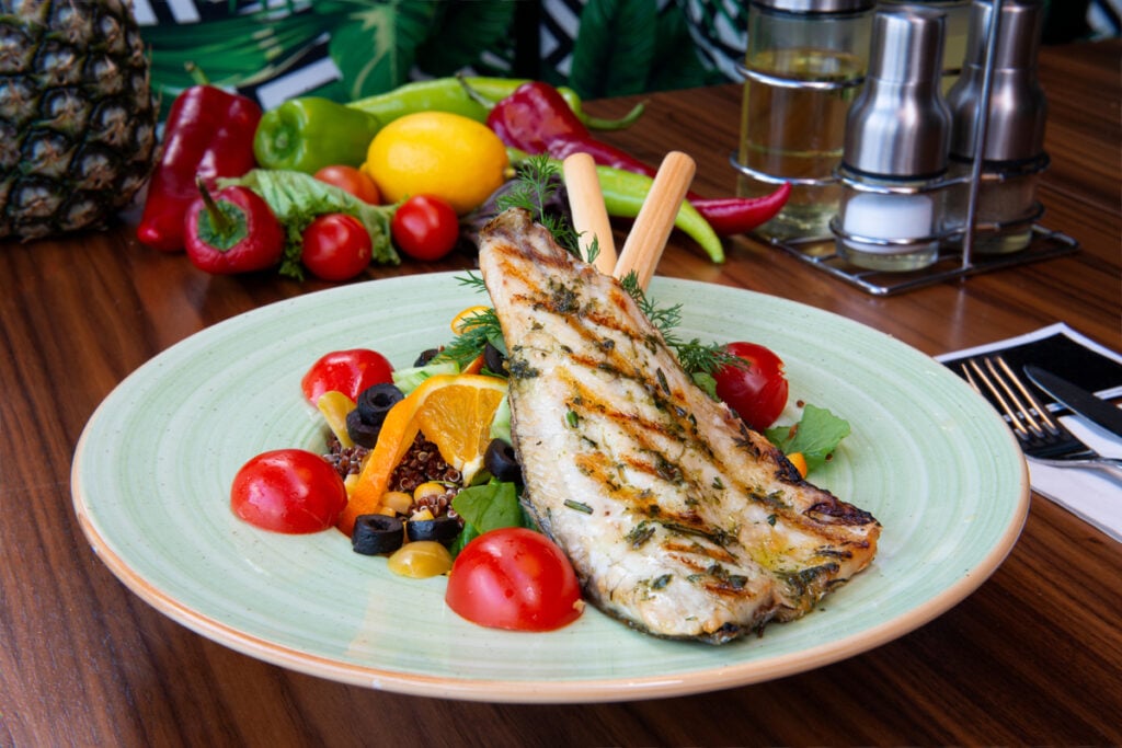 Filé de peixe grelhado com tomate-cereja, azeitona preta e alecrim