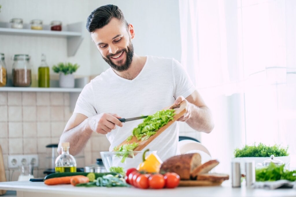 Homem na cozinha preparando uma refeição saudável