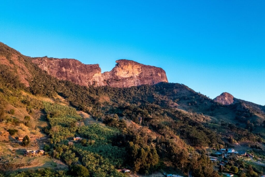 vista da Pedra do Baú com montanha, árvores e céu azul