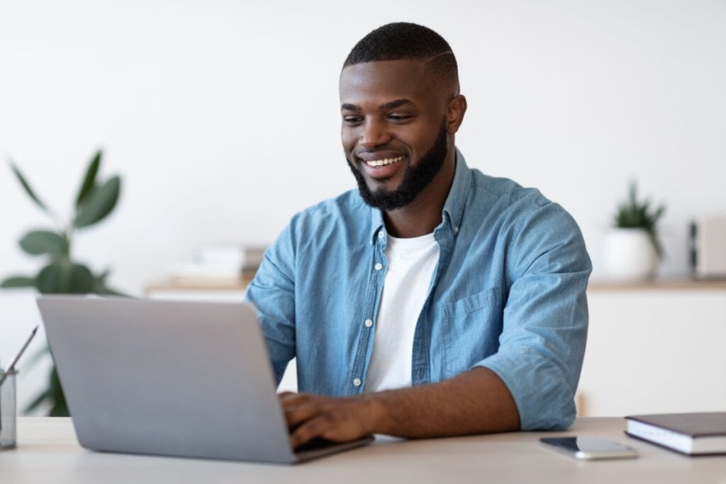 Homem sorrindo usando computador