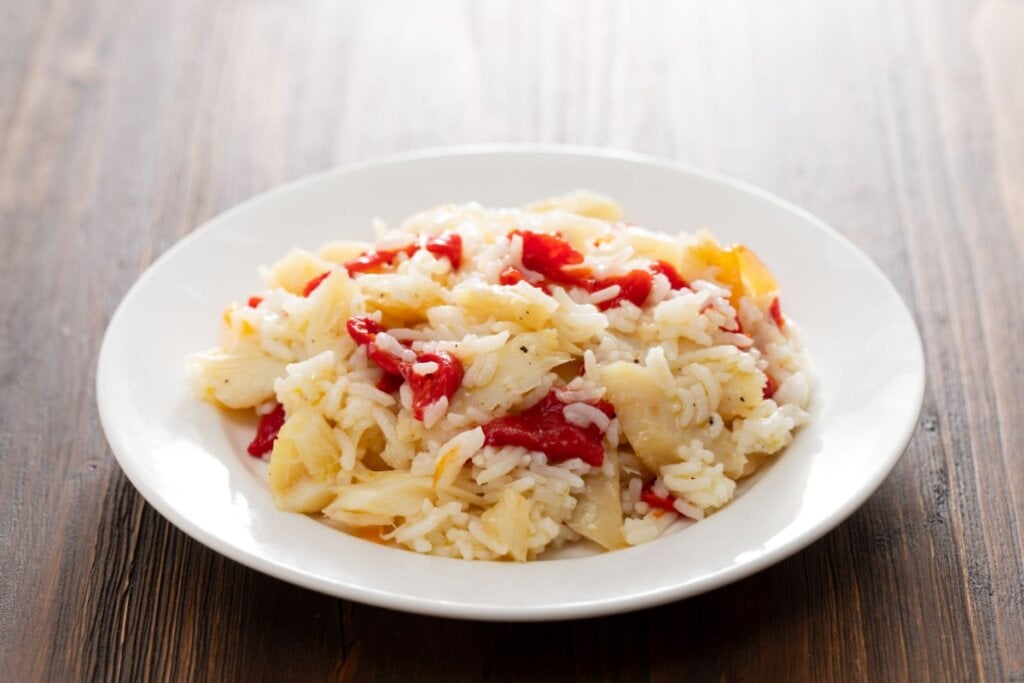 prato branco com arroz com bacalhau e pimentão vermelho