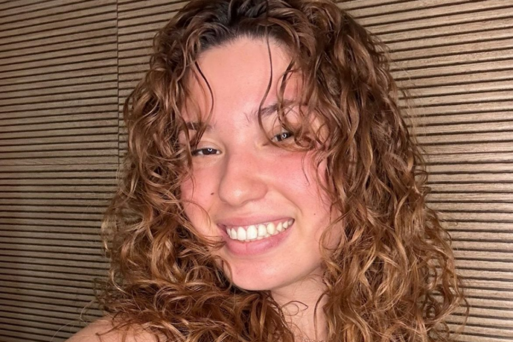 Mulher com cabelo ruivo fazendo pose para foto em salão de beleza 