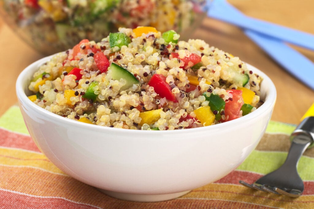 Salada de quinoa com pepino, tomate e pimentão em um recipiente branco