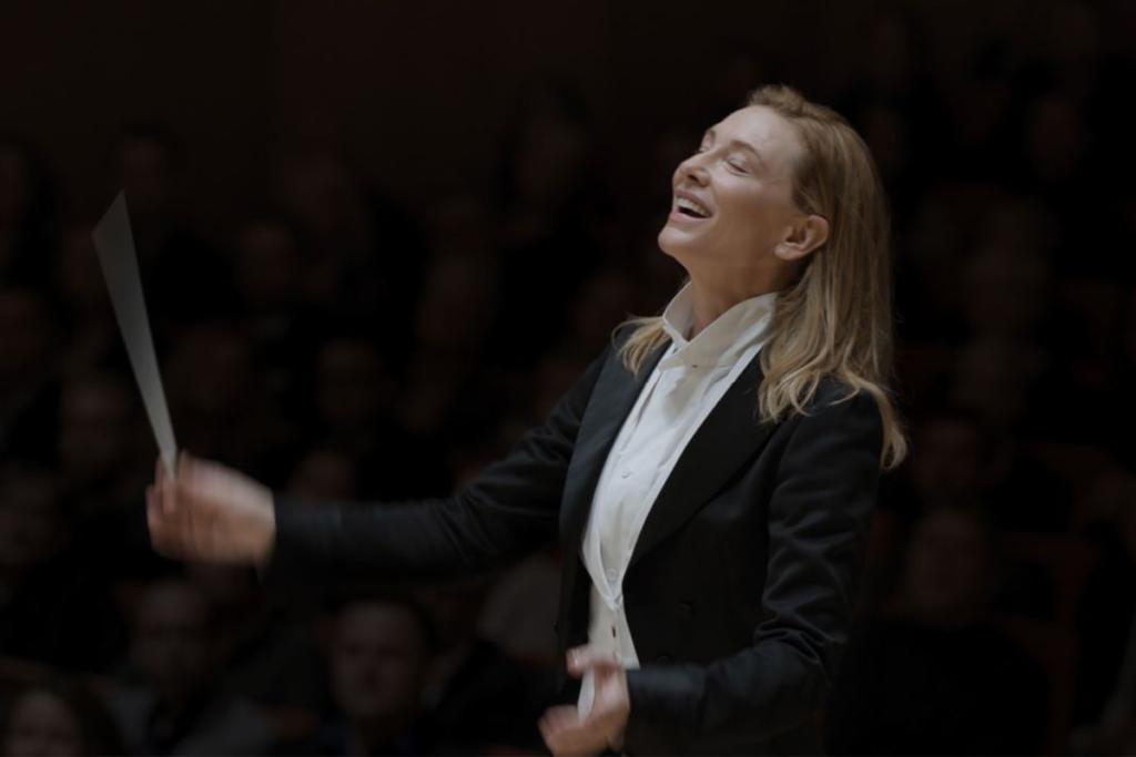 Imagem de Cate Blanchett em TÁR, interpretando Lydia Tár, uma renomada maestrina em um momento de condução