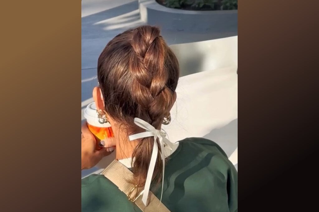 Cabelo em trança embutida finalizada com um laço de fita