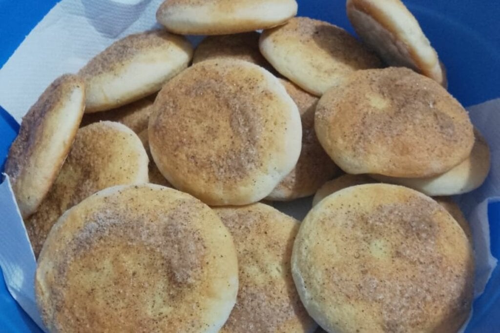 Biscoitos polvilhados com canela e açúcar em um recipiente com papel-toalha