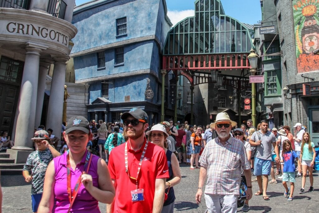 Pessoas usando boné e óculos de sol andando dentro do Walt Disney World