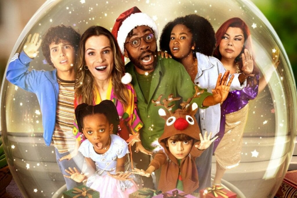 Capa do filme 'O Primeiro Natal do Mundo' com os atores um ao lado do outro dentro de um globo de neve 