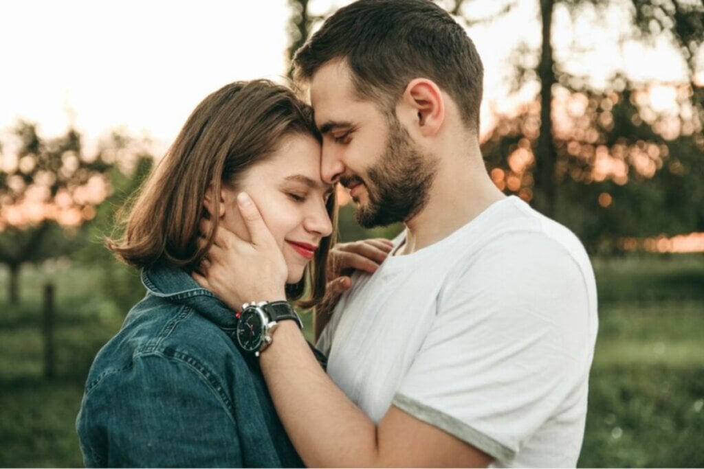 Casal em um parque com os rostos colados