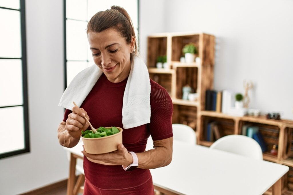 Mulher comendo salada de agrião após exercícios