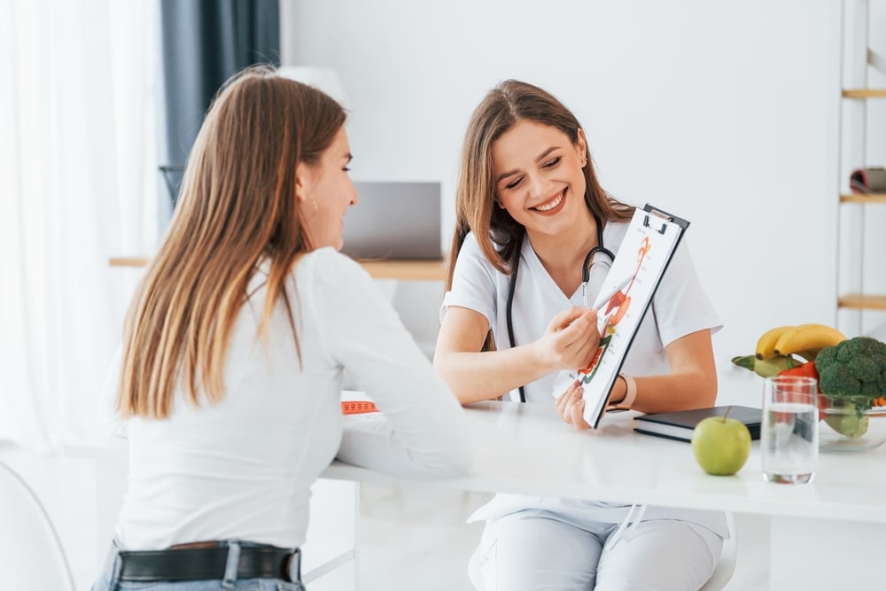 mulher em consulta com uma médica em uma sala de atendimento