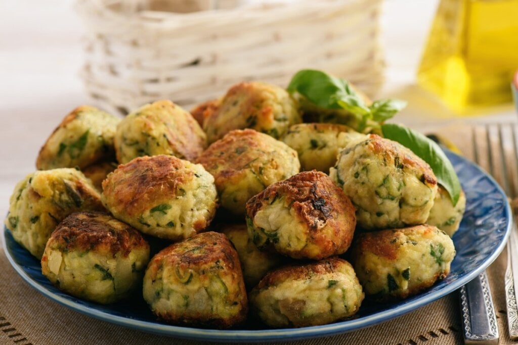 Bolinhos de grão-de-bico  com salsinha empilhados em um prato azul 