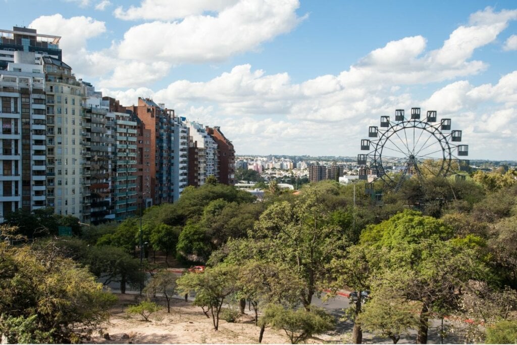 Imagem aérea da cidade de Córdoba, na Argentina com árvores, montanha-russa e prédios 