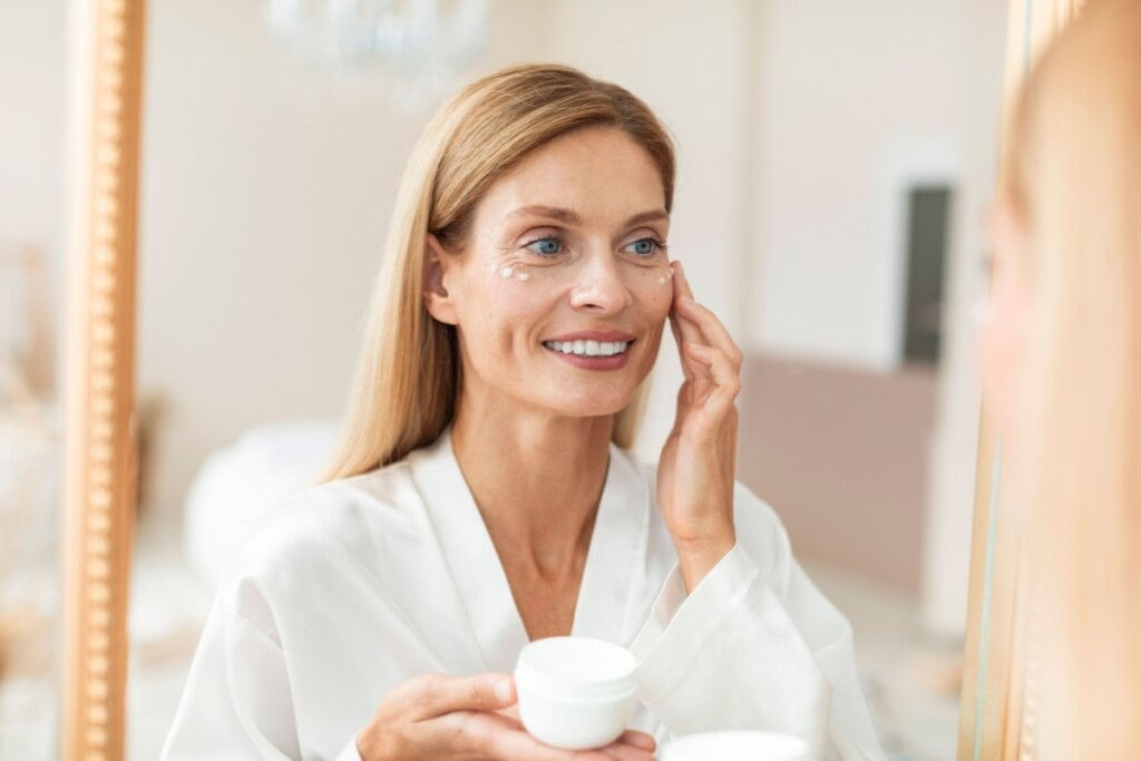 Mulher mais velha usando creme de hidratação no rosto