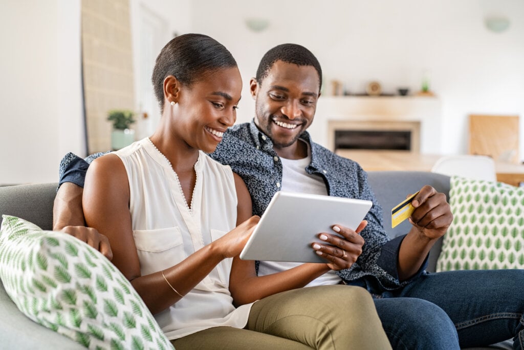 Mulher e homem sentados mexendo em tablet 