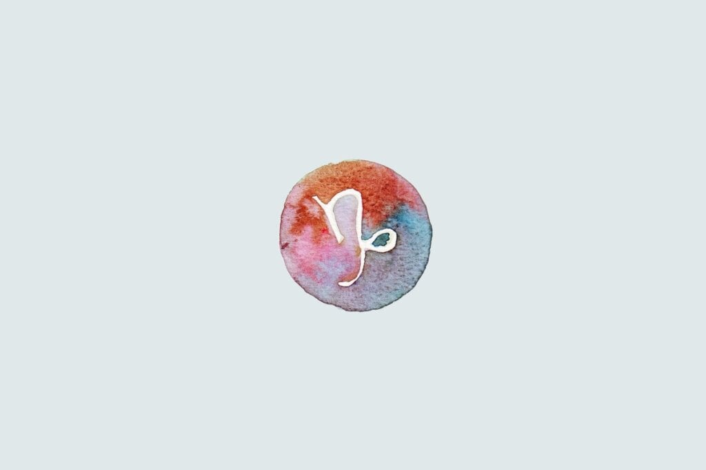 Veja as previsões do baralho cigano de junho para os 12 signos 69 Símbolo do signo de Capricórnio com traço curvado e espiral na ponta, sobre fundo colorido em estilo aquarela