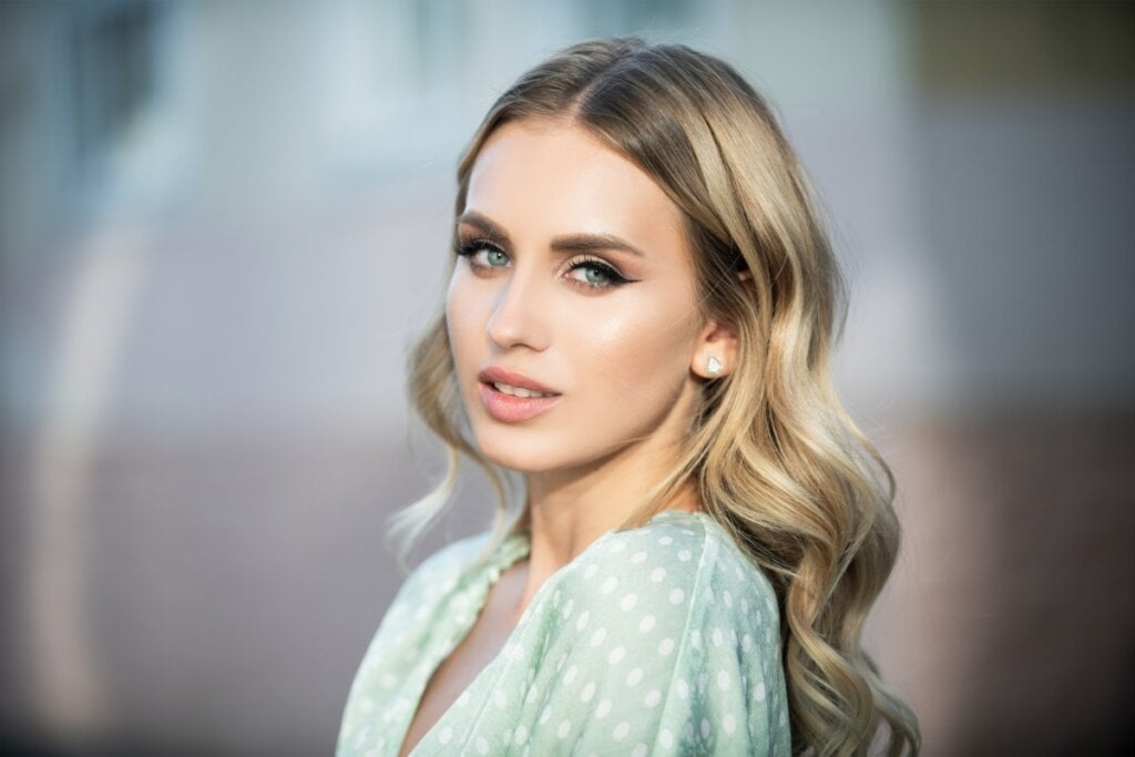 5 cores para transformar o cabelo para o inverno 21 Mulher usando um vestido branco com flores verdes, com o cabelo com ondas solto e olhando para o lado