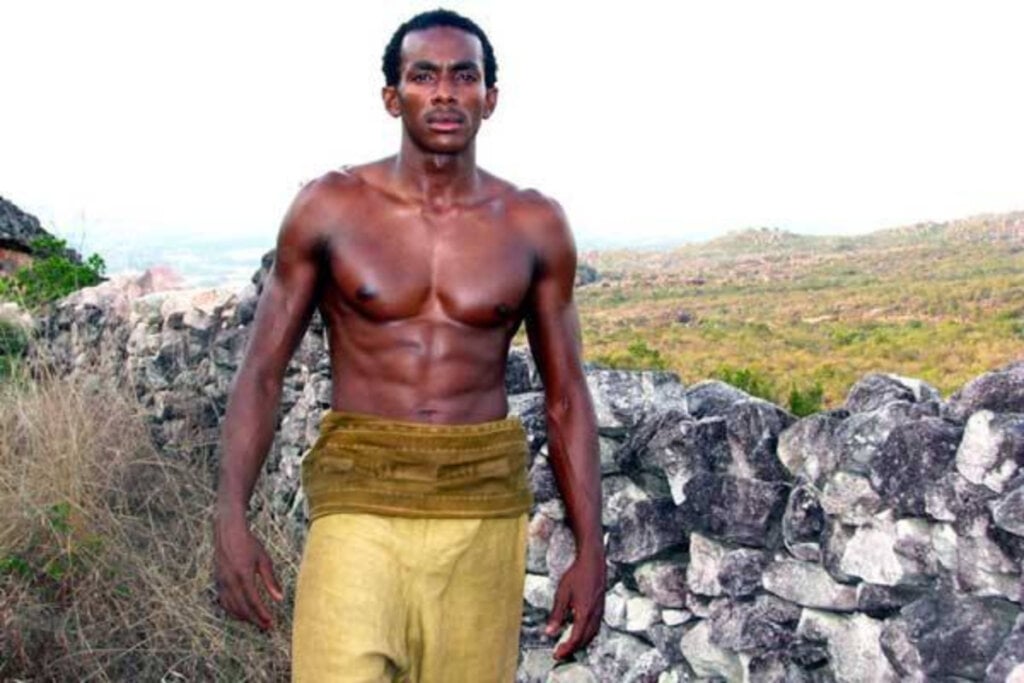 7 filmes essenciais sobre escravidão no Brasil e no mundo 33 Cena do filme "Besouro" com homem negro sem camisa e calça amarela