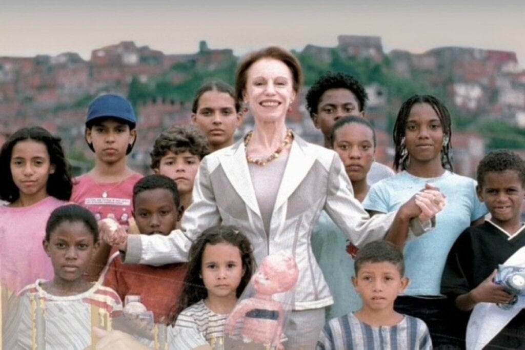 7 filmes essenciais sobre escravidão no Brasil e no mundo 32 Cena do filme "Quanto Vale ou É Por Quilo?" com mulher com roupa branca no centro e crianças de diferentes tamanhos em volta