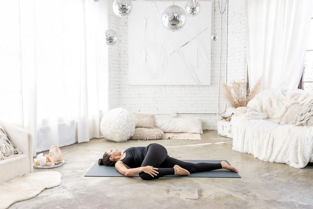5 posturas de yoga benéficas para as mães 23 Mulher deitada no chão fazendo postura de torção