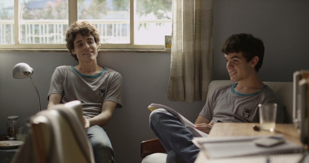8 filmes românticos para assistir no Dia dos Namorados 36 Dois meninos sentados conversando. Cena do filme "Hoje eu quero voltar sozinho".