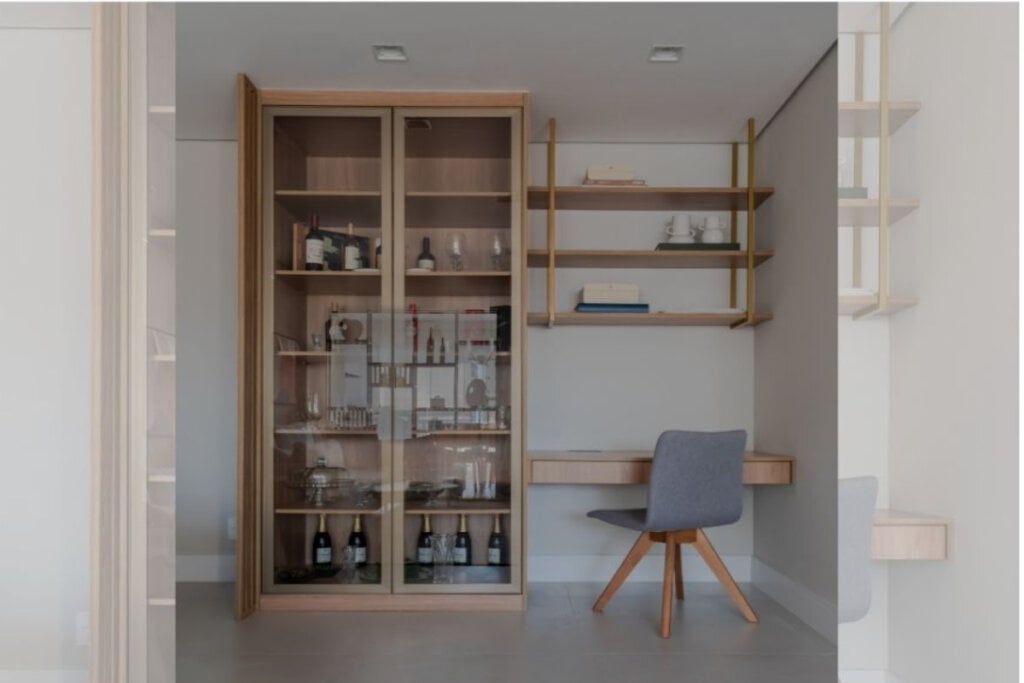 4 dicas para integrar o home office à sala de estar 18 imagem de home office com armário e prateleira de madeira clara e cadeira cinza