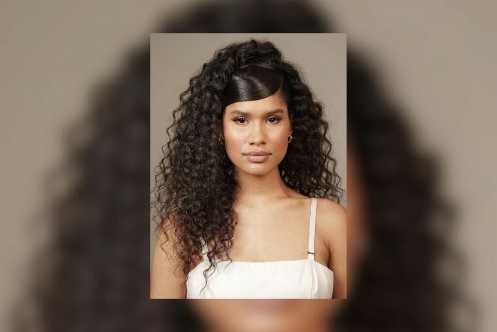 5 penteados diferentes para noivas que querem sair do óbvio 24 Mulher com cabelo semi preto. Franja lisa e fios cacheados soltos